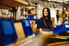 Smiling female working on a maleufacturing site.