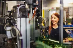 Womale operating a machine on a production site. 

