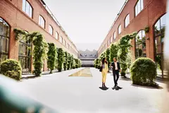 male and female walking and talking outside between office buildings.
