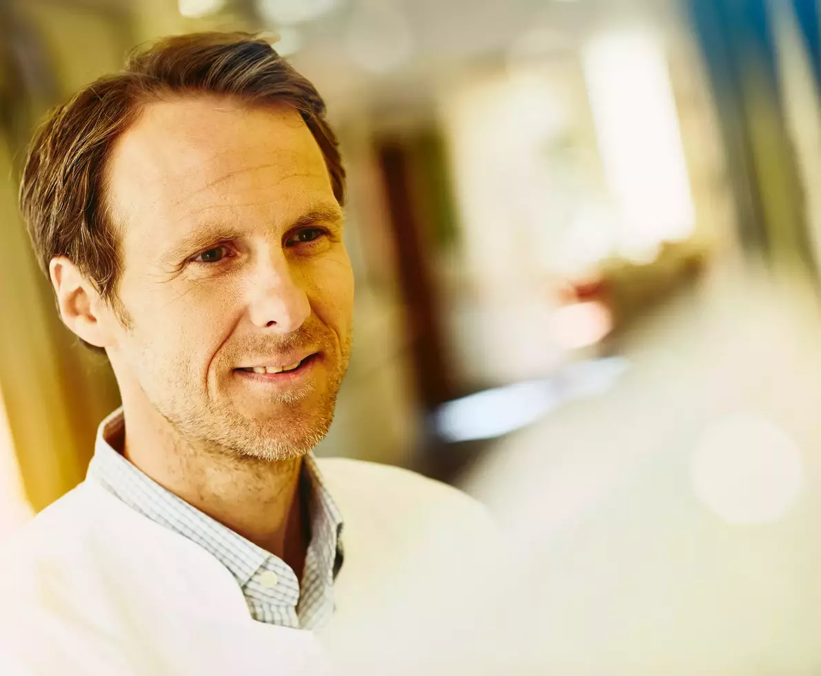 smiling man wearing lab coat